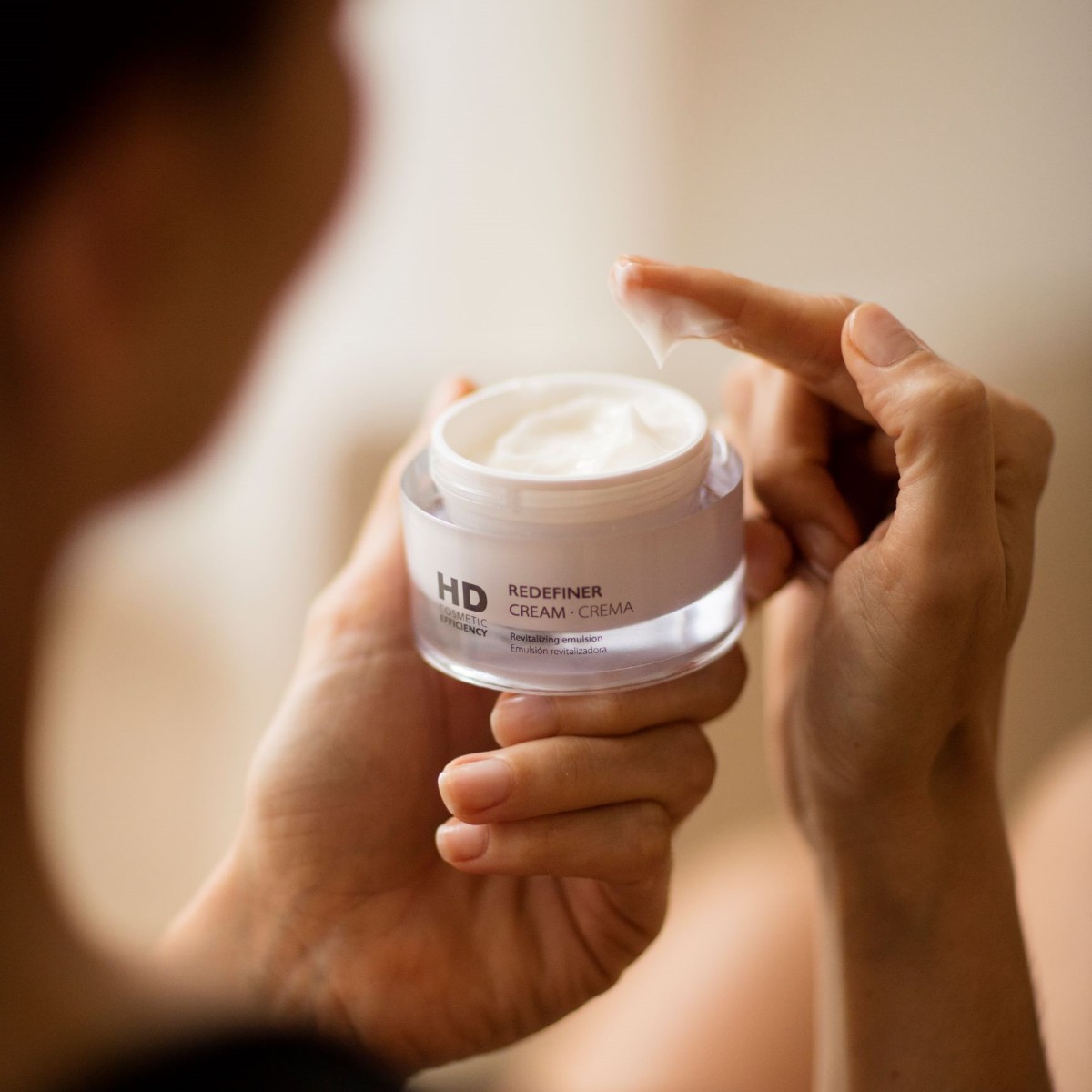 Femme appliquant la crème Redefiner - HD Cosmetic Efficiency