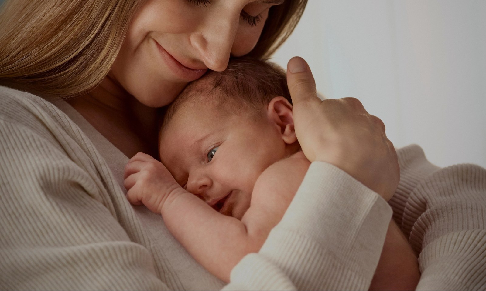 Maman serrant son bébé contre elle, univers Johnson's Baby