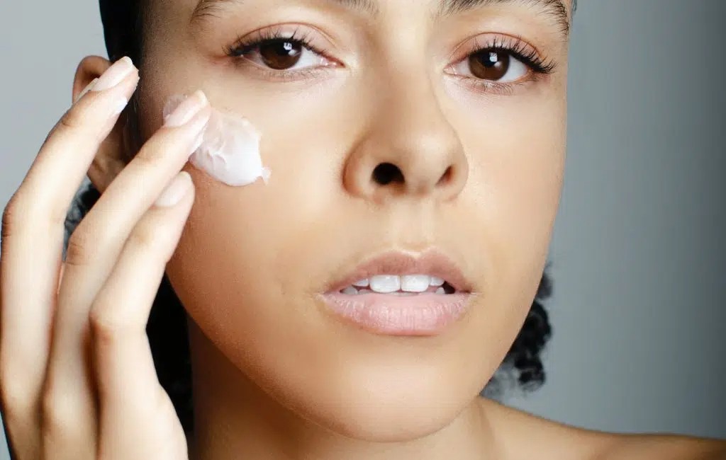 Application d’une crème sur le visage, univers New Derm