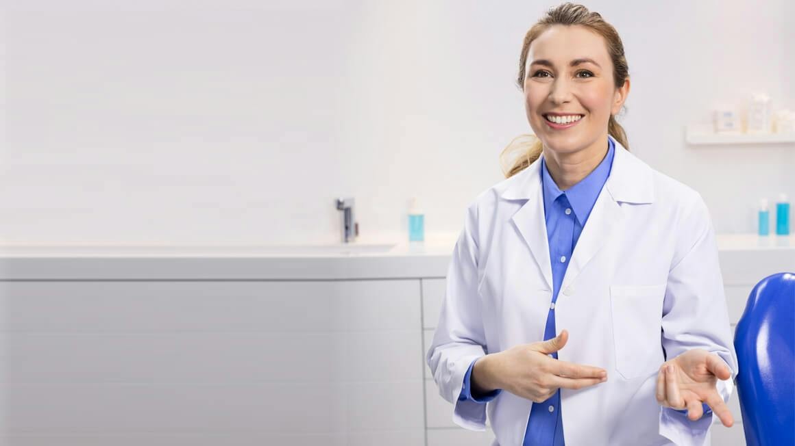 Dentiste souriante dans un cabinet dentaire - Sensodyne
