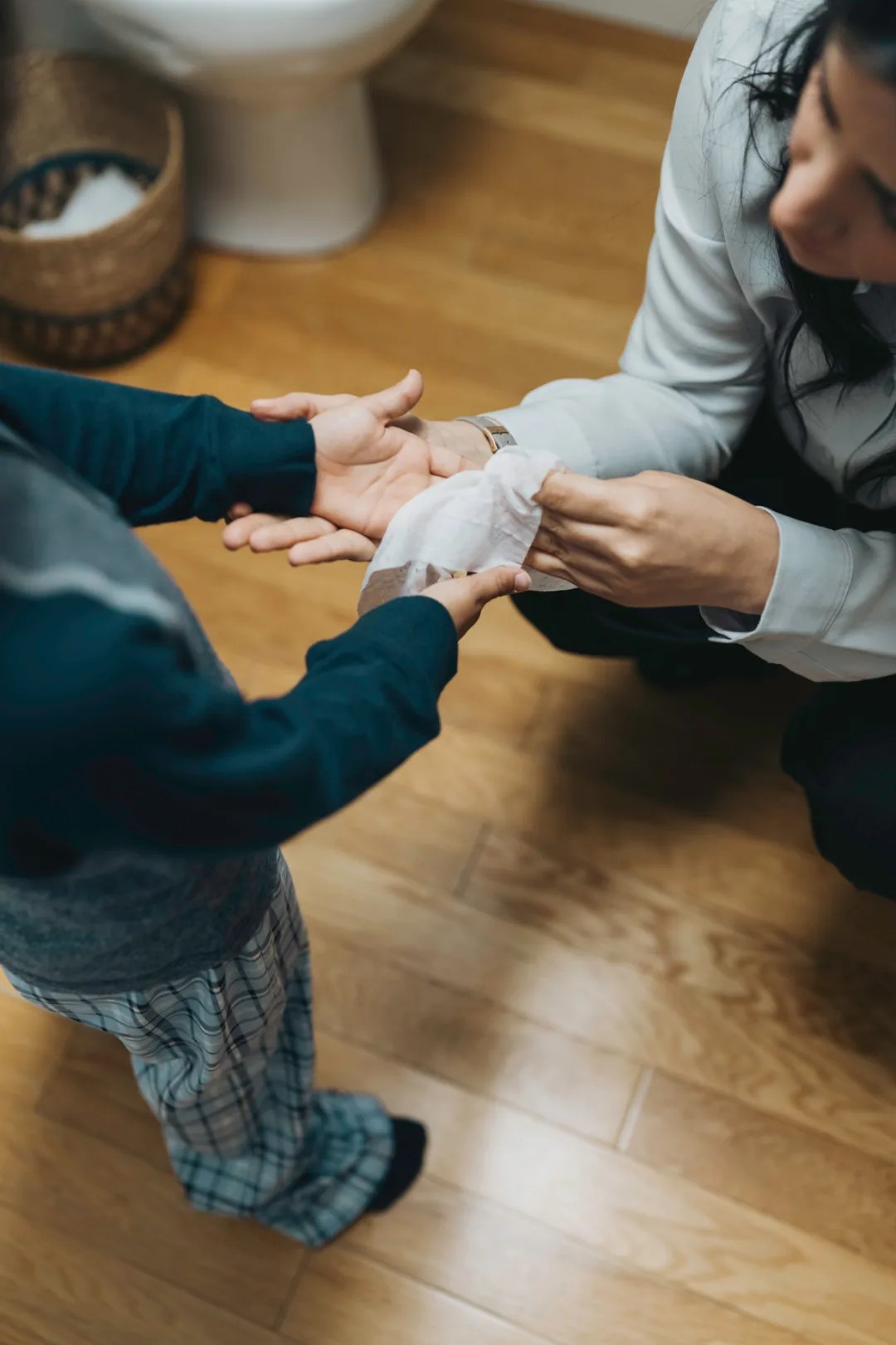 Parent nettoyant les mains d'un enfant avec une lingette WaterWipes